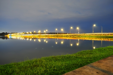 Lower Seletar Reservoir surrounded by green grass, road and the lightingsの写真素材