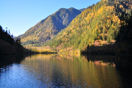 Mountain with colourful streak (reflection) on a lake at Jiuzhaigou, China, during Autumn seasonの写真素材