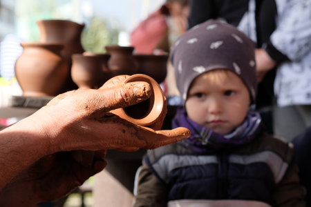 GDANSK, POLAND - SEPTEMBER 15, 2019: Outdoor event Kashubian Festival 735 years of Jasien. Potter shows the child ready clay vase.のeditorial素材
