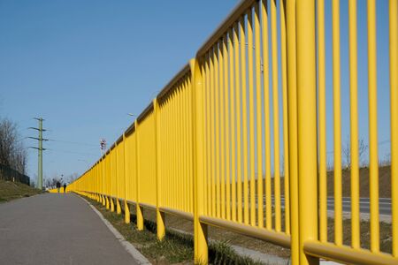 Yellow metal safety barriers along the pavement.の写真素材