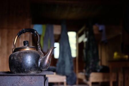 An old, sooty, metal kettle on the stove in mountain shelterの写真素材