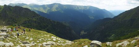 Romania, Romanian Carpathians - Fagaras Mountains, group of tourists resting on the trail in the Paltin Mountains, panoramaの写真素材