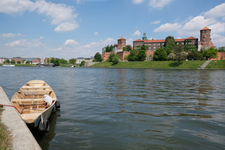 Wooden boat at the shore of Vistula River. In the background the Wawel Royal Castle. Cracow, Poland.のeditorial素材