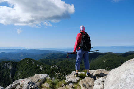 Mountain view with silhouette of standing woman tourist on viewpoint in beautiful National Park Risnjak, Croatiaの写真素材