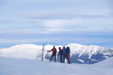 Low Tatras, Slovakia - circa February 2020: Beautiful winter mountain views during a snowshoe hike along the red ridge trail in the - tourist singpost at Kosarisko Peak and silhouettes of touristsのeditorial素材