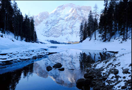 Winter mountain landscape - beautiful reflection of mountains in lake Lago di Braies, Alta Pusteria, Dolomites, Italyの写真素材