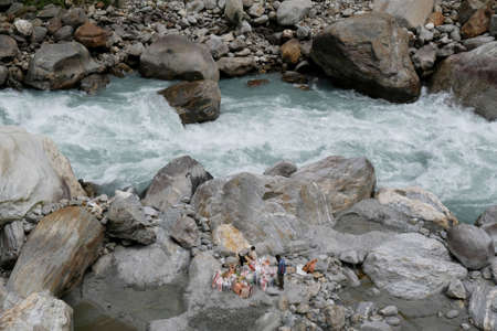 Foaming mountain Marsyangdi River in village Ghermu in Himalaya, Nepal. Silhouette of warking...