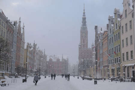 Dlugi Targ street in Gdansk Old Town in a snowy blizzard. Silhouettes of people on the street....
