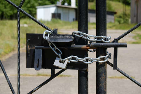 Metal gate closed with a chain and padlock