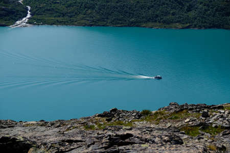Scenic Besseggen trail in Jotunheimen, Norway - the most beautiful trekking trail in Norway. Silhouette of standing man on viewpointの写真素材