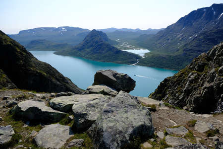 Scenic Besseggen trail in Jotunheimen, Norway - the most beautiful trekking trail in Norway. Silhouette of standing man on viewpointの写真素材