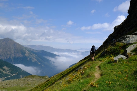 Beautiful mountain view above clouds during hiking on peak Djeravica (Gjerovica) - highest peak of Kosovo. Silhouette of lonely tourist on trail. Albanian Alps, Peaks of Balkansの写真素材