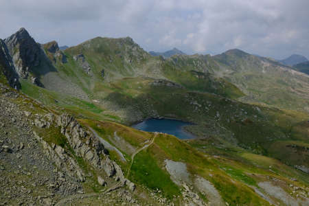 Beautiful mountain lake, view above clouds during hiking on peak Djeravica (Gjerovica) - the highest...