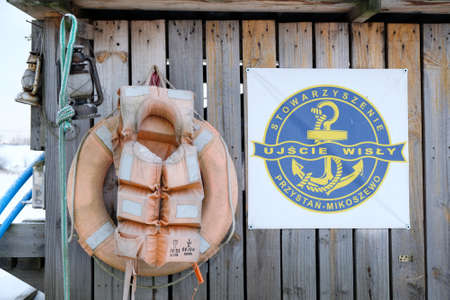 Mikoszewo, Poland - circa February 2021: Wooden hut with fishing equipment. There are fishing nets, buoy, lifebuoy and life vest on the wall. The mouth of the Vistula.のeditorial素材
