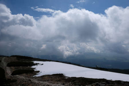 Babia Gora - mountain range in Beskid Zywiecki during spring with fog, clouds and sun