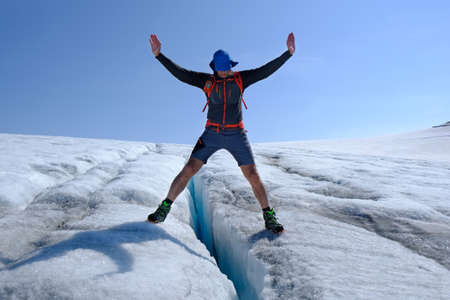 Silhouette of man who is standing over ice crevice on Jostedalsbreen Glacier. Jostedalsbreen National Park, Norwayの写真素材