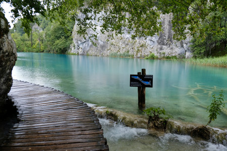 Amazing place - National Park of Plitvice Lakes, Croatia. Unusual turquoise color of lakes surrounded by the intense green of trees. The footbridge runs among the lakes.の写真素材