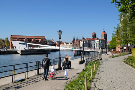 Family with small child on walk by Motlawa river in Old Town in Gdansk, Poland