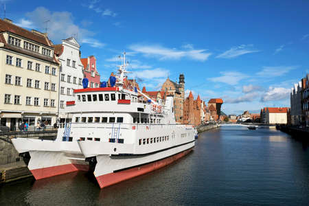Big white cruise ship stands on quayside of Motlawa canal in Old Town of Gdansk, Poland.の写真素材