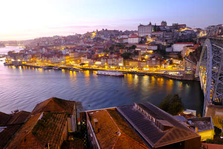 Roof of buildings and panorama of Porto on river in night scenery, Portugal.の写真素材