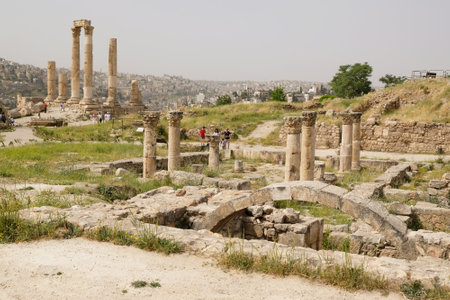 Amman, Jordan - circa May 2022: Ruins of Citadel Jebel Al Qala'a in Amman. Silhouettes of people standing among column.のeditorial素材