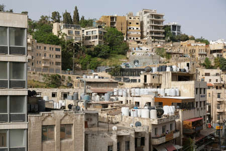 Amman, Jordan - circa April 2022: Buildings in the center of Amman, view from high over roofs with big water canistersのeditorial素材