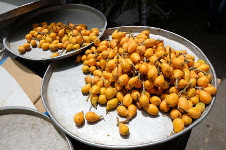 Fruits loquat (Eriobotrya japonica) are laying on big metal plates in market stall in Amman, Jordan