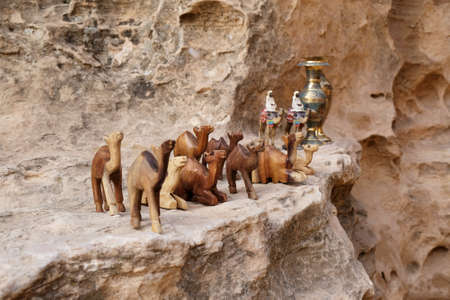Souvenir figurines of wooden camels stand on rock in Little Petra, Jordanの写真素材