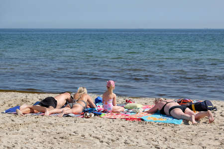 The family is sunbathing on the beach by the seaの写真素材