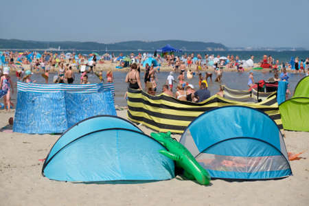 A lot of colorful screens and tents on beach. Crowds of people by the sea in Jelitkowo at the mouth of the Oliwa Stream. Gdansk, Polandの写真素材