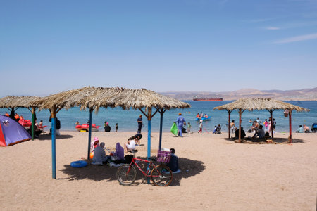 Aqaba, Jordan - circa June 2022: Beach with straw roofs on the Red Sea in Aqaba, Jordanのeditorial素材