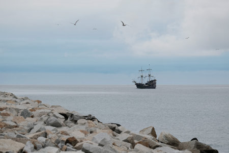 Little silhouette of sailing ship on horizon on sea
