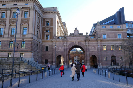 STOCKHOLM, SWEDEN - circa February 2023: People walking in the streets of Stockholm through the Parliament House, Swedish: Riksdagshusetのeditorial素材