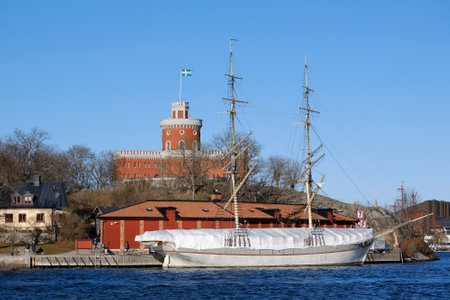 Stockholm, Sweden - circa February 2023: The beautiful historical Kastellet citadel on the islet Kastellholmen and sailing ship standing by the shore in central Stockholm, Swedenのeditorial素材
