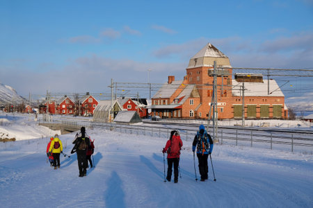 Group of tourists with snowshoes are going to railway station in Abisko in winter scenery. Abisko National Park (Abisko nationalpark) in winter scenery. Sweden, Arctic Circle, Swedenの写真素材