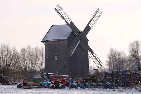 Mokry Dwor, Poland - 7 January 2024: A historic wooden windmill in the village of Mokry Dwor in...