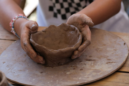 A close-up of a person's hands making a pot out of clayの写真素材