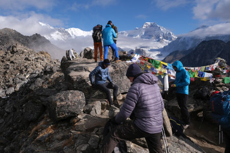 Gokyo, Nepal - 4 November 2024: Group of people on peak Gokyo Ri and amazing mountain panorama of Himalayas in background. Gokyo is famous region in Himalayas in Nepal.のeditorial素材