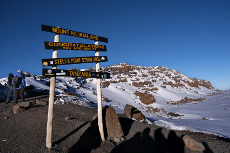 Kilimanjaro, Tanzania: Board infrormation, peak sign on Stella Point on Kibo volcano (Kilimanjaro) â 5895 m with Mount Meru in backgroundの写真素材
