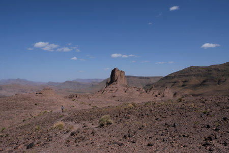 Amazing mountain landscapes of Jebel Saghro with volcanic rocks eroded by wind and time and little silhouette of single man. Atlas, Anti Atlas, Moroccoの写真素材