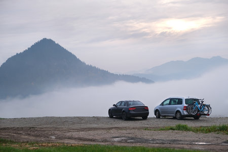 Two cars are standing on mountain viewpoint in misty scenery in Pieniny Mountains, Polandの写真素材