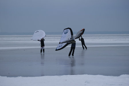 Frozen Bay of Puck (Baltic Sea) and little silhouettes of people on ice, Pomerania, Polandの写真素材