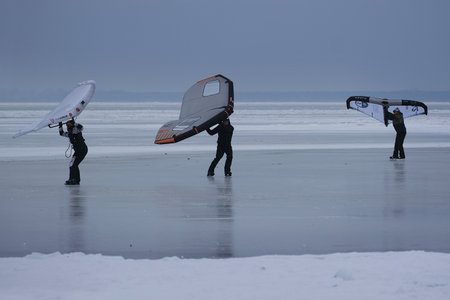Frozen Bay of Puck (Baltic Sea) and little silhouettes of people with wings on ice, Pomerania,...