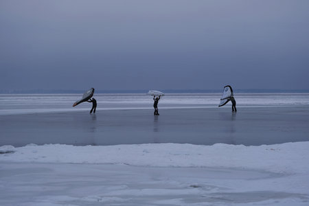Frozen Bay of Puck (Baltic Sea) and little silhouettes of people with wings on ice, Pomerania, Polandの写真素材