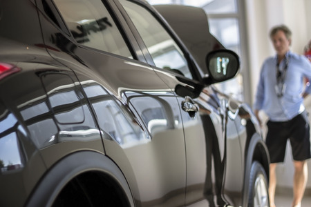 A man choosing new car at dealershipの写真素材