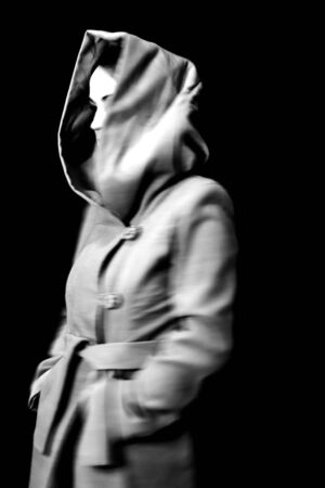 Blurry portrait of a woman in hood. Black and white studio shot.の写真素材