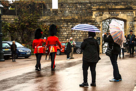 Tourist looking at Queen's Guard at Windsor Castle. Berkshire, England, UK.のeditorial素材