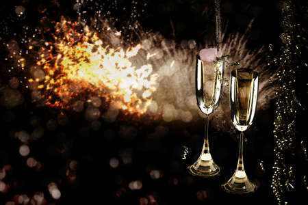 New Year background with champagne glasses and firework display on black background. Happy New Year.の写真素材