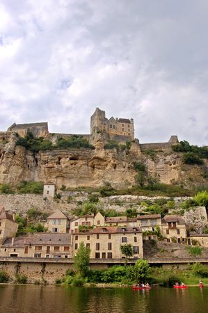 The Chateau de Beynac  towering over the town of Beynac on the banks of the Dordogne river, France on warm hazy afternoonの写真素材