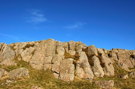 Rock feature and deep blue sky on summit of Dunmore, Scotlandの写真素材